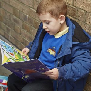 Child reading on doorstep