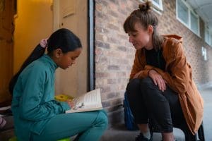 Rachel reading with a child during one of her visits.