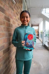child-smiling-with-book-london