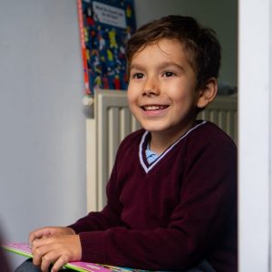 child-smiling-with-book-doorstep